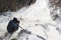 Erwin Christis photographing sea foam in a geo (coastal chasm) near Portnahaven, Islay, Scotland.