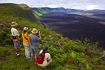 Hikers admire the view from the caldera rim of the Chico Volcano, Sierra Negra, Isabela Island, Galapagos, January 2009