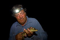Stephen Fry with Spectacled caiman at night, filming BBC TV series 'Last Chance to See' in the Brazilian Amazon, Jan 2008