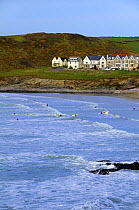 Surfers in the sea at Polzeath. Cornwall, UK. Blue Flag Beach.