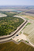 Aerial view of the US / Mexico border wall in Hidalgo County showing how wildlife corridors are severed, reduced or eliminated by the wall, Lower Rio Grande Valley wildlife corridor, Texas, USA ILCP R...
