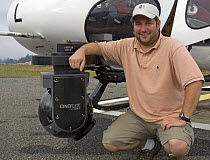 Dave Manton, from the BBC filming crew for 'South pacific' beside helicopter, Papua New Guinea, August 2007. Dave is beside a cineflex HD gyrostablised mount used to film stabilised aerials of landsca...