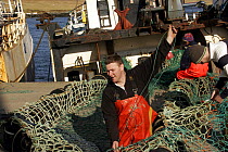 Philip Stephen, photographer and skipper of "Carisanne", mending nets. Cullivoe, Unst, Shetland, April 2008. Model Released.