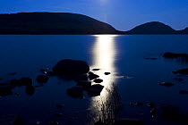 Moonlight reflected in Eagle Lake, Acadia National Park, Maine, USA. Cadillac Mountain (left) and Pemetic Mountain (right) are in the distance, July 2008