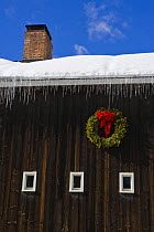 A christmas wreath on a traditional wooden barn, Grafton, Vermont, USA. February 2008