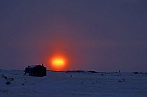 Sunset behind cabin, old Inupiaq village of Point Hope, Arctic coast of Alaska, March 2008