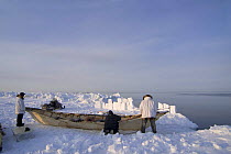 An Inupiaq whaling crew at the edge of an open lead in the pack ice wait behind a snow blind and watch for passing whales during spring whaling season, off the Arctic coastal village of Point Hope, Ch...