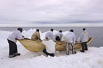 An Inupiaq whaling crew prepare to paddle their seal skin boat / umiak, in an open lead in the Chukchi Sea, during spring whaling season, off the Arctic coastal village of Point Hope, Alaska, May 2008