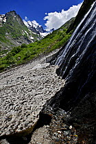 Water flowing down a rock face and underneath a glacier, Amanauz Valley near Dombay, Teberdinsky biosphere reserve, Caucasus, Russia, July 2008