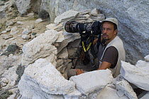 Photographer, Stefano Unterthiner, in stone hide to photograph Eleonora's falcons (Falco eleonorae) Antikythera, Greece, September 2008