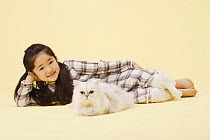 Young girl lying on ground with Chinchilla silver persian cat