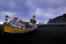 Fishing boat hauled up on black sand beach of Vik, southern Iceland 2005