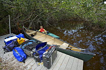 Russell Laman in kayak, and gear ready to load in canoe for camping trip on the Hell's Bay Canoe Trail. Everglades National Park, Florida, USA. Model released, April 2008