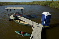 Russell Laman in kayak beside the Hell's Bay Chickee camping platform in the mangroves of the Hell's Bay Canoe Trail, Everglades National Park, Florida, USA. Model released, April 2008