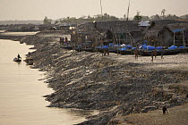 Nolian village with Shrimp fry fishing boats pulled up on the mudflats of the Sibsa River at low tide, Sundarbans, Khulna Province, Bangladesh, March 2006