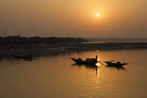 Sunrise over the Sibsa river at Nolian Village with shrimp fry fishing boats, Sundarbans, Khulna Province, Bangladesh, March 2006
