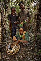 Honey hunter team leader Mathab Gazi (seated) and team members with the basket of the first honey collected for the season, Sundarbans, Khulna Province, Bangladesh, April 2006