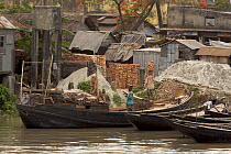 Men unloading bricks from a boat by carrying them on their head. Sundarbans, Khulna, Bangladesh, April 2006