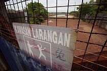 No trespassing sign at the gate to a major industrial shrimp farming complex, carved out of the mangroves. Kedah, Malaysia.  May 2006