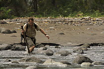 Photographer, Christian Ziegler, wades across the Rio Ole, Bioko Island, Equatorial Guinea, Rapid Assessment Visual Expedition, International League of Conservation Photographers, January 2006. Model...