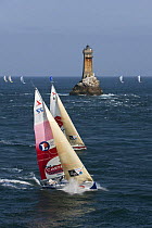 Yachts passing lighthouse at Raz De Sein, Finistere, Brittany, during the Tour de Bretagne, September 2009.