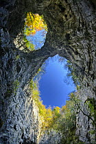 Looking up at the sky through the twin openings in a collapsed cave ceiling, Zelske Jame, Skocjan Karst Gorge, Rakov Skocjan, Slovenia, Europe, October 2007