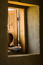 Child looking in through window, Anja reserve, near Ambalavao, Central Madagascar, April 2007