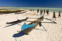 Children play on beach beside traditional fishing boats, Itampolo, South Madagascar, May 2007