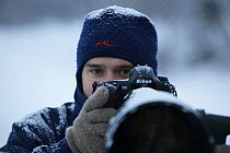 Photographer, Sven Zacek, with camera, in snow, Finland, February 2009