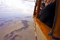 Tourists in the basket of hot air balloon looking down over the Namib desert, Sossusvlei, Sesriem, Namib desert, Namibia, August 2008