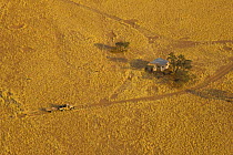 Aerial view of truck approaching isolated building in the Namib desert, seen from a hot air balloon, Sossusvlei, Sesriem, Namib desert, Namibia, August 2008