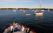 People taking photographs from the foredeck of a boat off Newport, Rhode Island, USA. 2009.