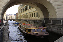 Tourist boat passing under a bridge on one of the many channels of the River Nega in St Petersburg, Russia, June 2007
