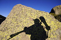 Shadow of photographer, Staffan Widstrand, carrying photography equipment, on rock, Sierra de Gredos, Spain, November 2008