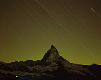 Matterhorn (4,478m) at night, long exposure with star trails, viewed from Gornergrat, Switzerland, September 2008, climbers in foreground with headlamps setting off to climb the Matterhorn from Hornli...