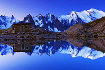 Aiguilles de Chamonix with Mont Blanc (4,810m) right, reflected in Lac Blanc with small mountain hut at dawn, Haute Savoie, France, Europe, September 2008