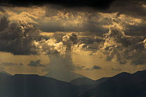 Sun shining through clouds, Pollino National Park, Basilicata, Italy, May 2009