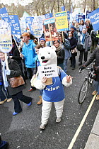 Person dressed as a Polar bear holding a sign saying 'Save Humans Too!!' part of 'The Wave' climate change march ahead of the Copenhagen climate summit, London, UK, 5th December 2009