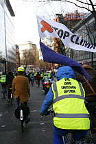 Cyclists, part of 'The Wave' climate change march ahead of the Copenhagen climate summit, slogan on luminous jacket stating 'The zero emission option' London, UK, 5th December 2009