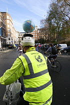 Cyclists, part of 'The Wave' climate change march ahead of the Copenhagen climate summit. Cyclist with globe on cycle helmet, London, UK, 5th December 2009
