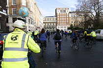 Cyclists, part of 'The Wave' climate change march ahead of the Copenhagen climate summit. Cyclist with globe on helmet, London, UK, 5th December 2009