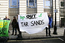 People holding sheets stating 'bp out of tar sands' at road side, part of 'The Wave' climate change march ahead of the Copenhagen climate summit, London, UK, 5th December 2009