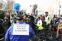 Cyclists, part of 'The Wave' climate change march ahead of the Copenhagen climate summit. Sign on someone's back stating 'Clean up on carbon', London, UK, 5th December 2009