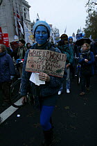 Person with blue painted face carrying sign stating 'Wake up World! Man made climate change is real' part of 'The Wave' climate change march ahead of the Copenhagen climate summit, London, UK, 5th Dec...