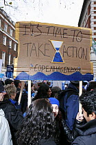 Sign with an hourglass stating 'It's time to take action' being carried by people in The Wave climate change march ahead of the Copenhagen climate summit, London, UK, 5th December 2009