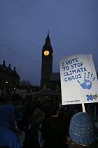 Protesters near Big Ben at dusk, part of 'The Wave' climate change march ahead of the Copenhagen climate summit, signs stating 'I vote to stop climate chaos' London, UK, 5th December 2009