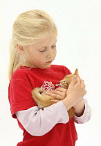 Girl cuddling ginger kitten, 7 weeks, model released