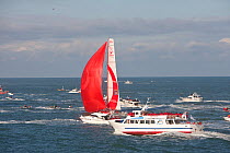 Spectator boat and "Veolia Environment" (Roland Jourdain and Jean-Luc Nelias) at the start of the Transat Jacques Vabre race, departing Le Havre, France. 8th November 2009.