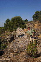 Photographer, Pete Oxford, next to hide, Sierra de Andújar Natural Park, Mediterranean woodland of Sierra Morena, north east Jaén Province, Andalusia, Spain, May 2009