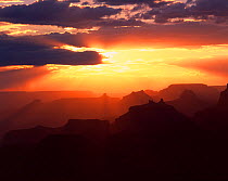 View from Navajo Point to the west with the sun's rays silhouetting Angels Gate, Isis, Shiva and Zoroaster Temples next to Wotons Throne at sunset, Grand Canyon National Park, Arizona, USA